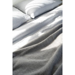 Gray comforter on a bed with pillows