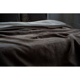 Brown textured blanket on a surface with a neutral background