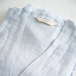 A detail picture of the waffle bathrobe with Sömn hang tag #color_opal-sky